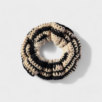 Scrunchie de croche numa mistura de preto e bege.